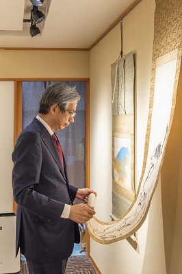 社長が掛軸を見る